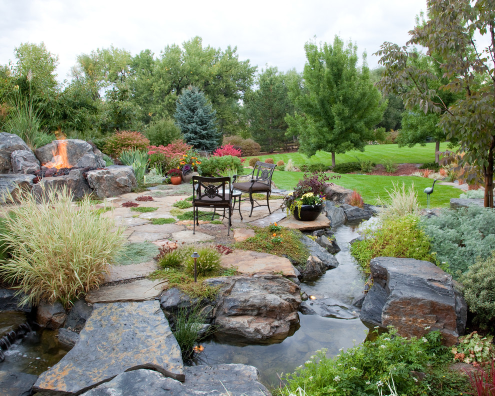 Foto de jardín rural de tamaño medio en patio trasero con jardín francés, fuente y adoquines de piedra natural