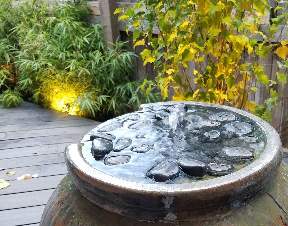 Halbschattiger Asiatischer Garten neben dem Haus, im Sommer mit Wasserspiel und Dielen in Denver