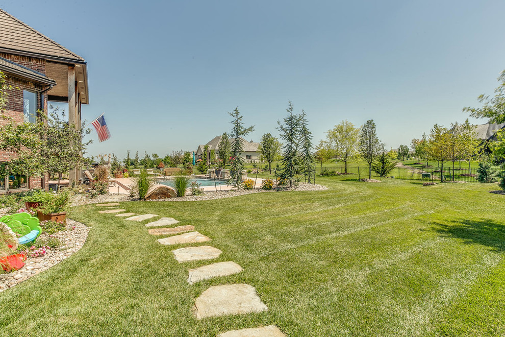 Großer Klassischer Gartenweg im Sommer, hinter dem Haus mit direkter Sonneneinstrahlung und Natursteinplatten in Wichita