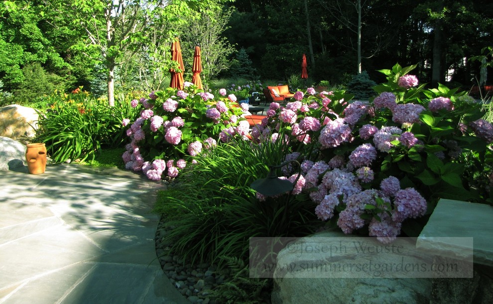 Immagine di un giardino tradizionale esposto a mezz'ombra di medie dimensioni e dietro casa in estate con pavimentazioni in pietra naturale