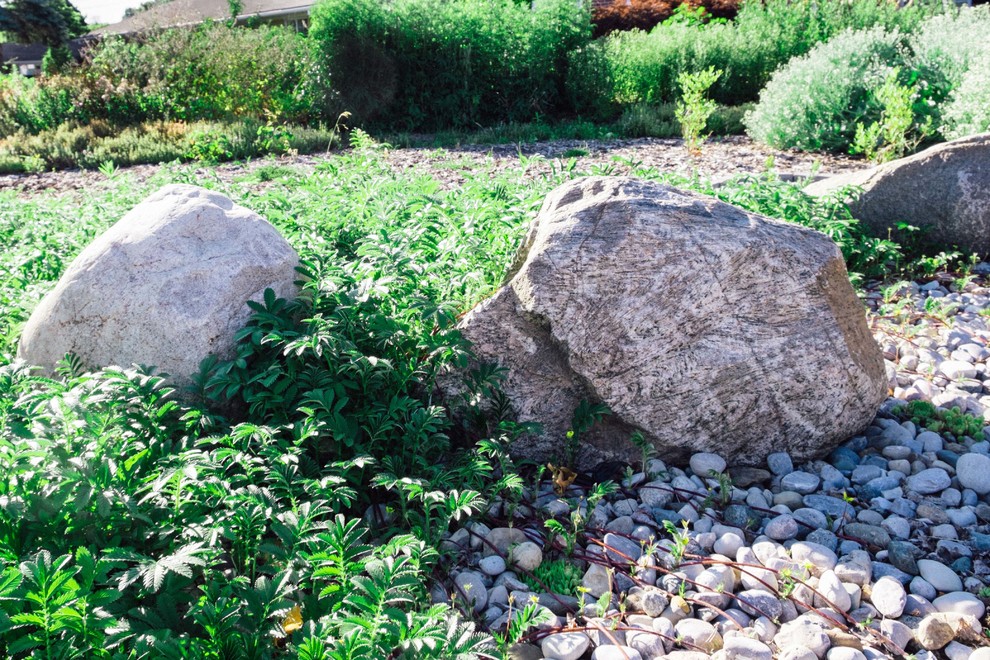 This is an example of a mid-sized transitional full sun backyard stone landscaping in Toronto for summer.