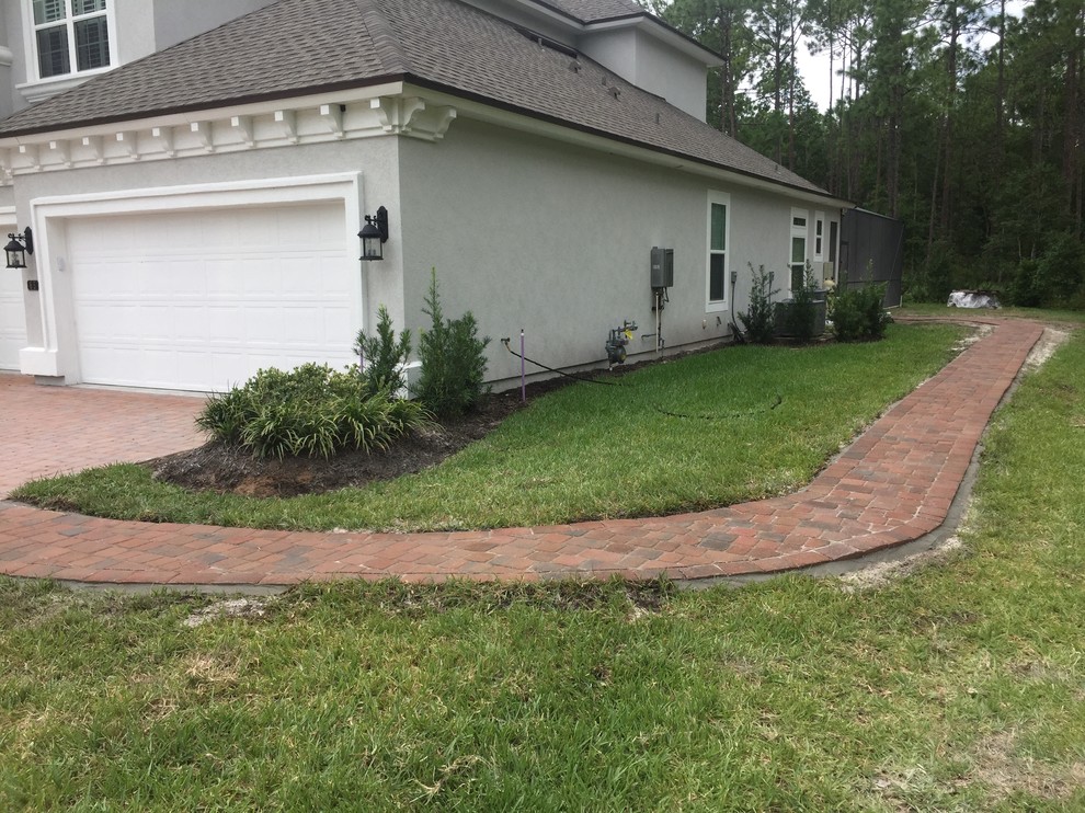 Inspiration for a medium sized world-inspired side driveway full sun garden in Jacksonville with a garden path and brick paving.