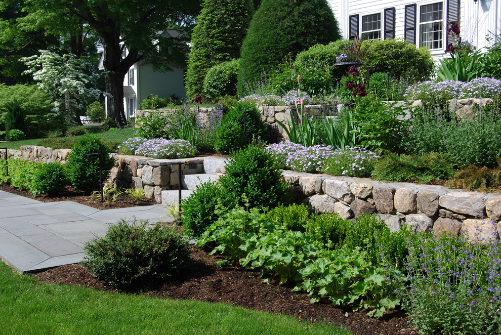 Immagine di un grande giardino classico esposto in pieno sole davanti casa con pavimentazioni in pietra naturale