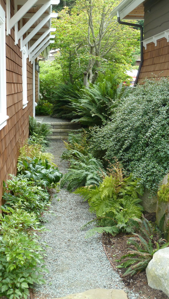 Foto di un giardino tradizionale in ombra di medie dimensioni e nel cortile laterale in primavera con un ingresso o sentiero e ghiaia