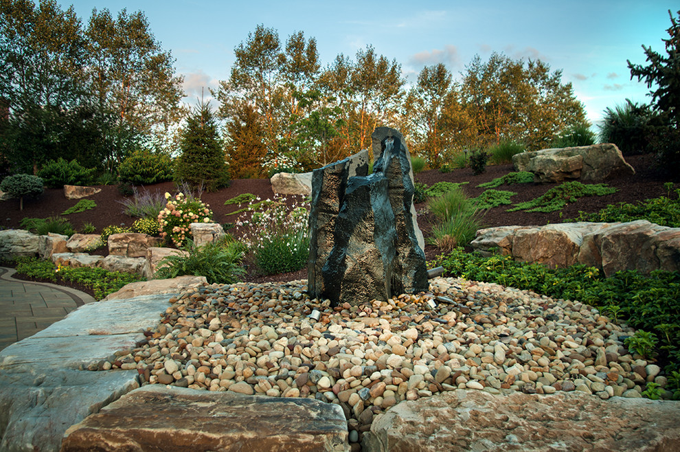 Inspiration pour un grand jardin à la française arrière design avec un point d'eau, une exposition partiellement ombragée et des pavés en pierre naturelle.