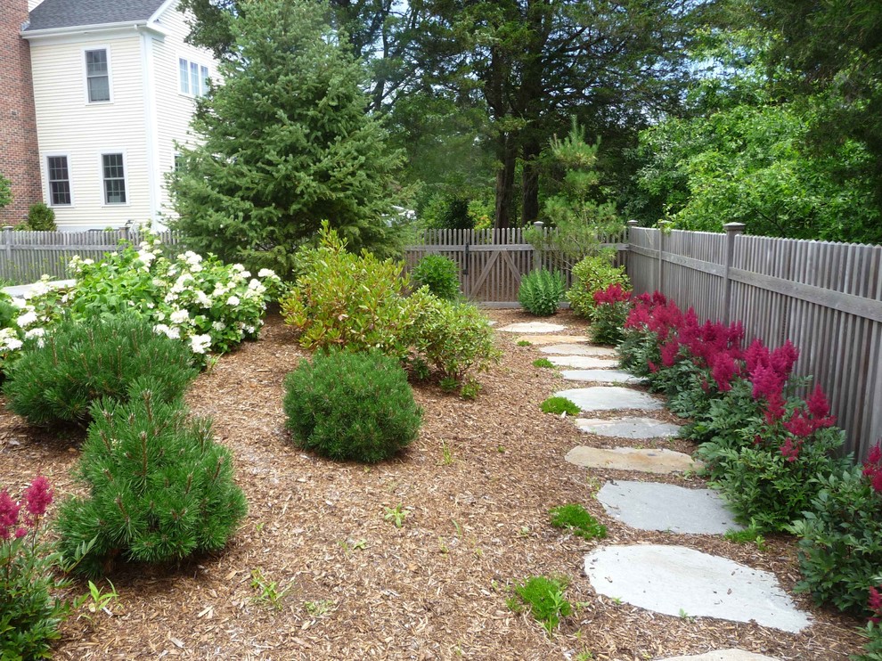 This is an example of a classic partial sun garden for summer in Bridgeport with a garden path and natural stone paving.