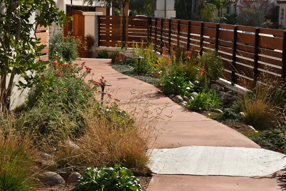 Kleiner Mediterraner Gartenweg neben dem Haus mit direkter Sonneneinstrahlung und Betonboden in San Diego