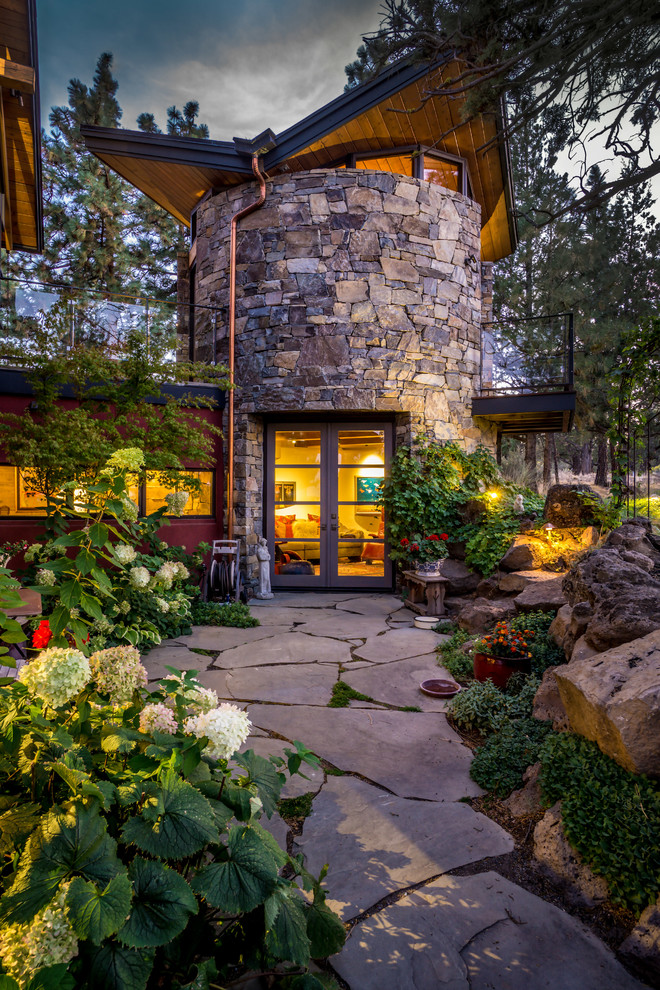 Design ideas for a large rustic full sun backyard stone landscaping in Other.
