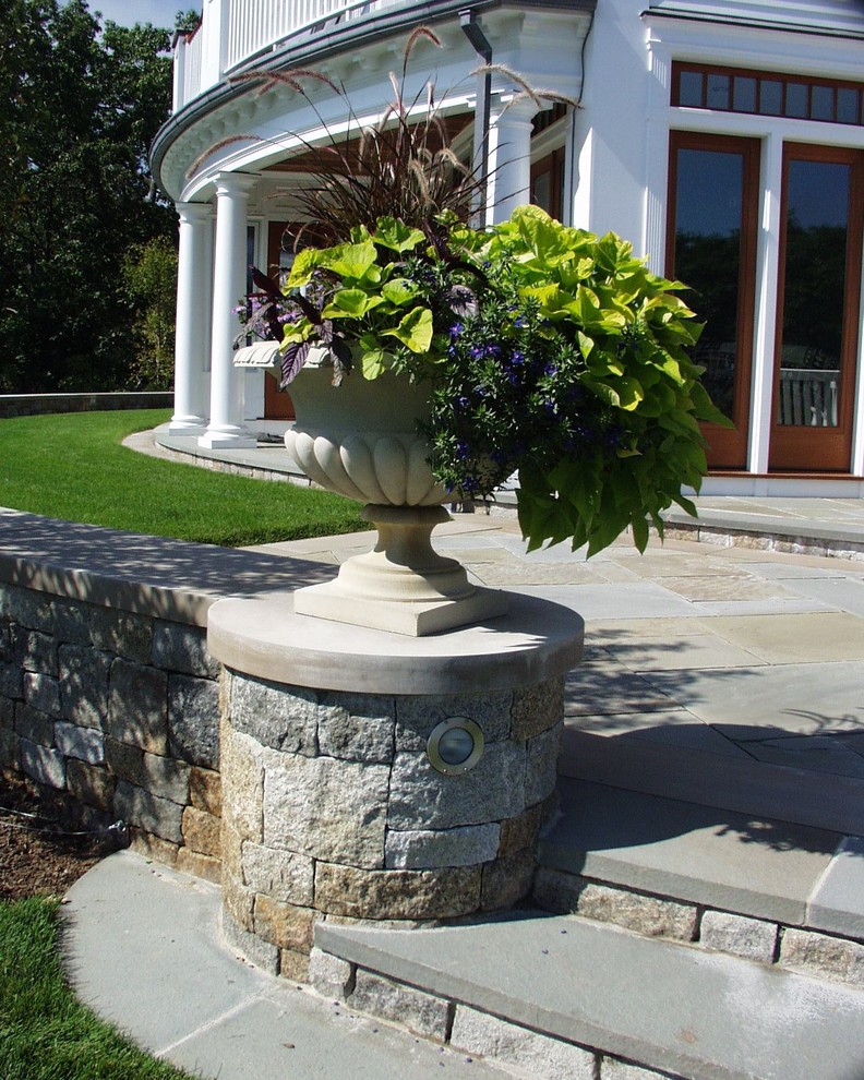 Пример оригинального дизайна: большой регулярный сад на боковом дворе в классическом стиле с растениями в контейнерах, полуденной тенью и покрытием из каменной брусчатки