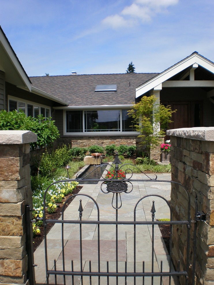 This is an example of a large traditional full sun front yard stone landscaping in Seattle.