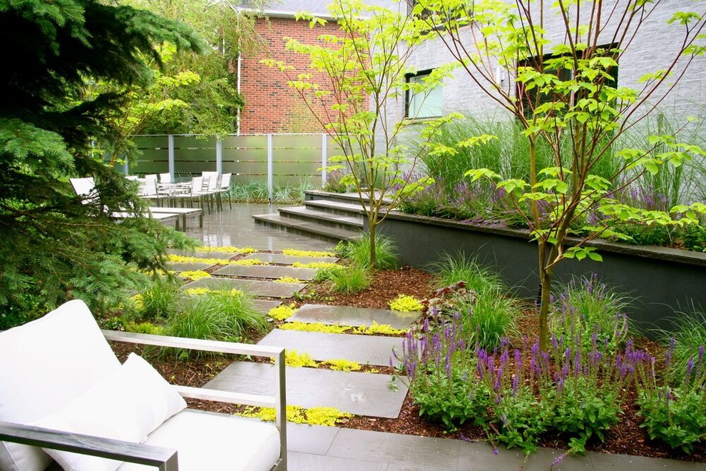 Inspiration för stora moderna trädgårdar i delvis sol, med en öppen spis och naturstensplattor