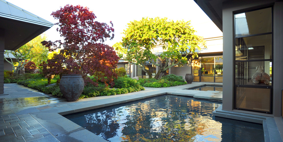 На фото: большой летний участок и сад на внутреннем дворе в современном стиле с покрытием из каменной брусчатки и садовой дорожкой или калиткой с