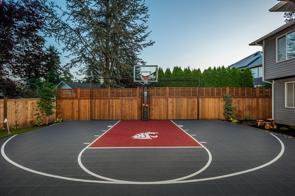 Medium sized traditional back private garden in Seattle with an outdoor sport court, decorative stones and a wood fence.