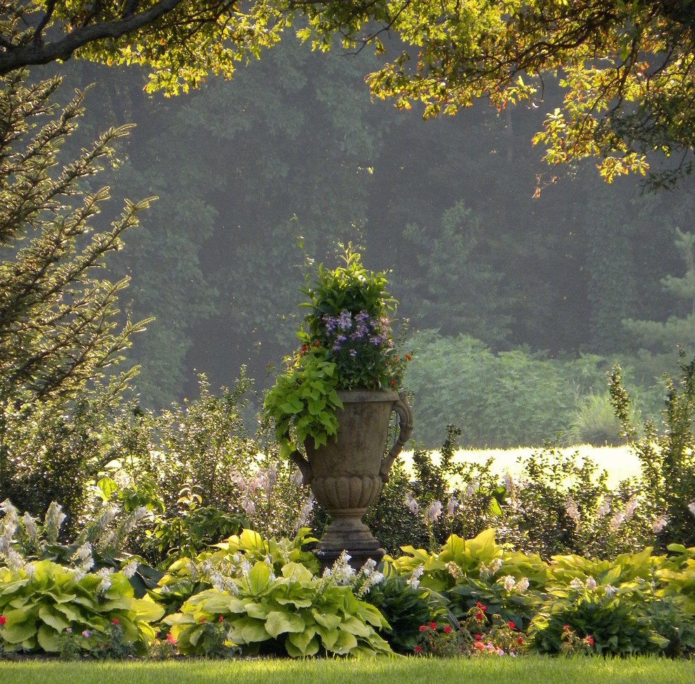 Пример оригинального дизайна: большой летний участок и сад на заднем дворе в классическом стиле с растениями в контейнерах и полуденной тенью
