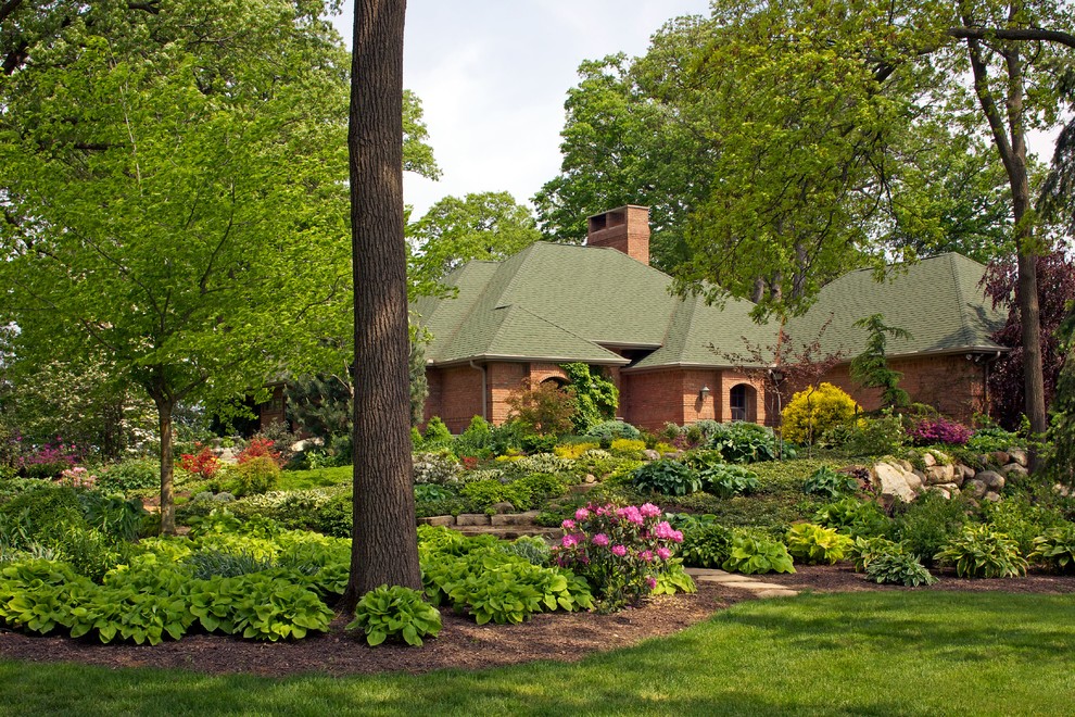 Diseño de jardín actual extra grande en verano en patio delantero con exposición parcial al sol y adoquines de piedra natural