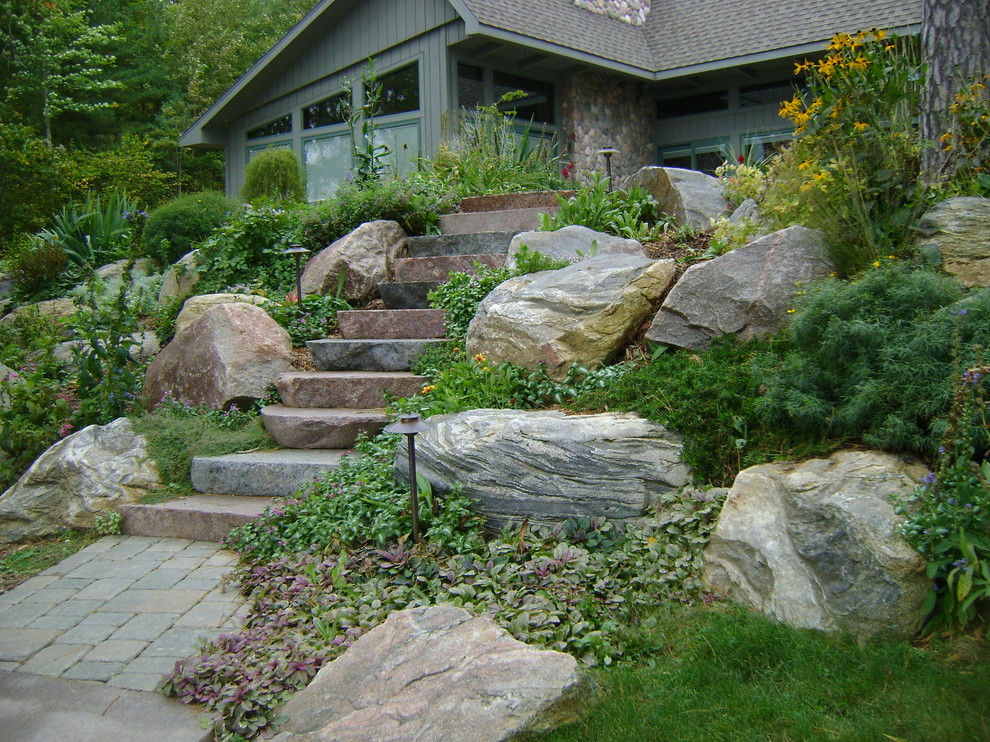 Design ideas for a traditional sloped garden in Other with natural stone paving.