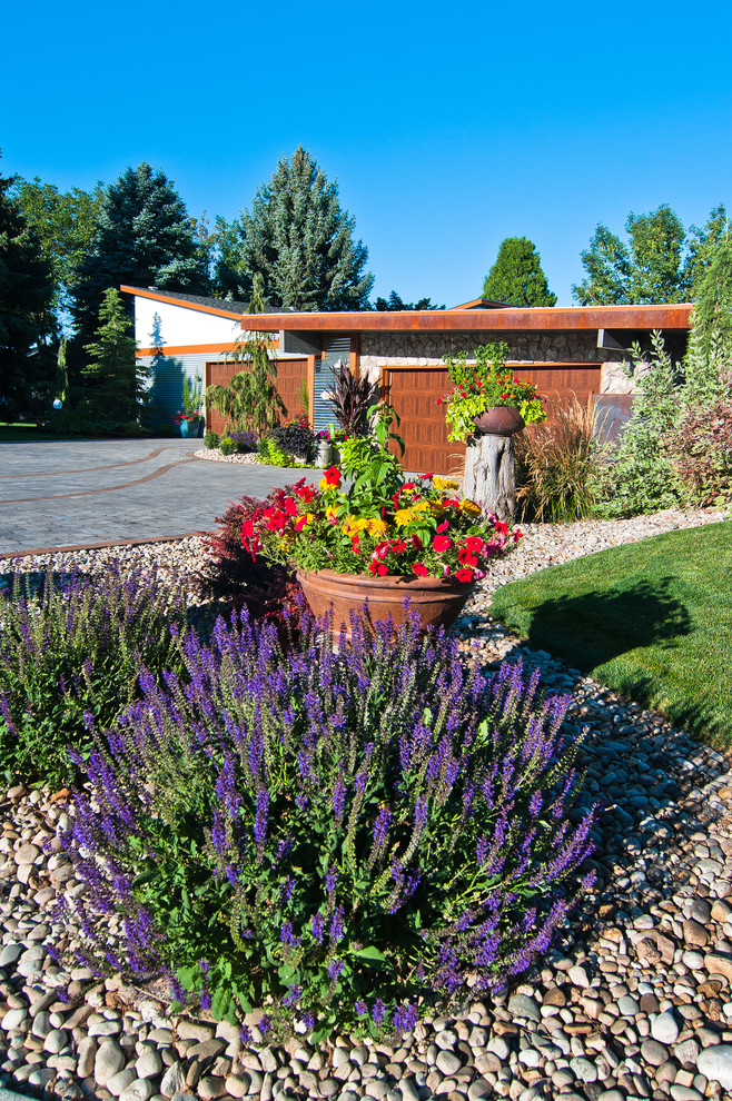 Eklektischer Vorgarten mit Auffahrt, Kübelpflanzen und Betonboden in Boise