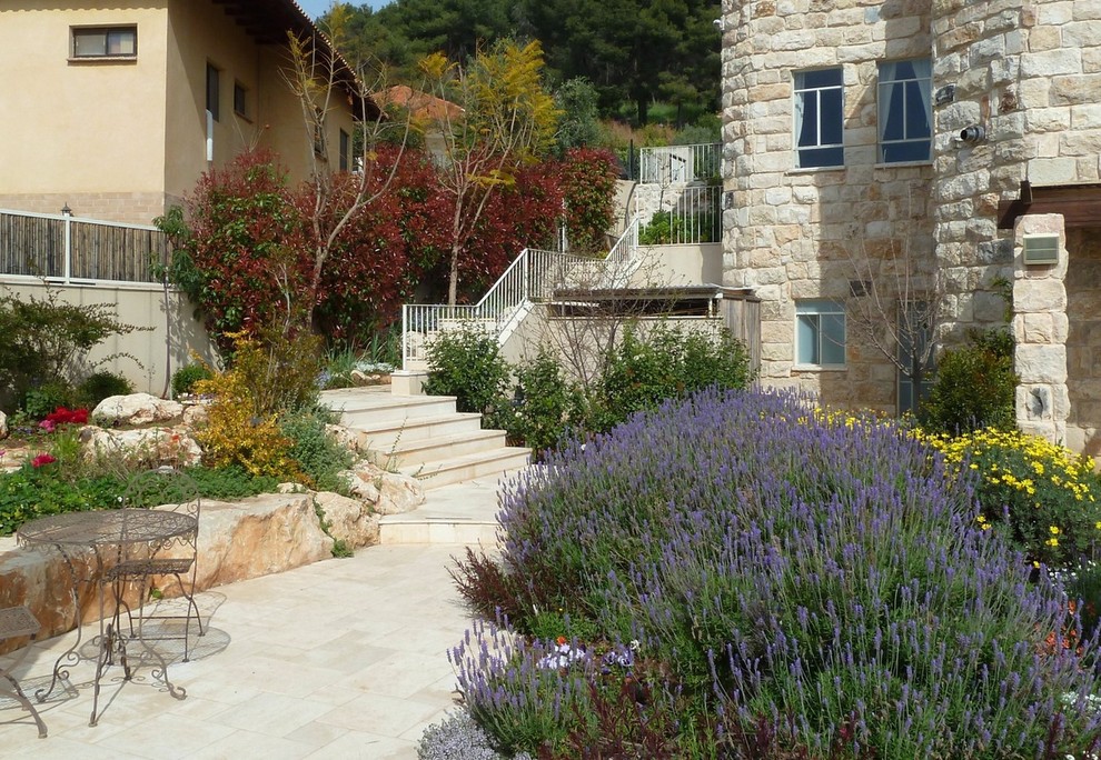 Ejemplo de jardín mediterráneo en patio trasero con exposición total al sol y adoquines de piedra natural