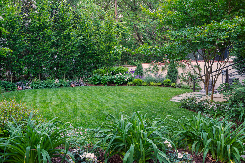 Cette image montre un jardin à la française arrière traditionnel de taille moyenne et l'été avec une exposition ensoleillée et des pavés en pierre naturelle.