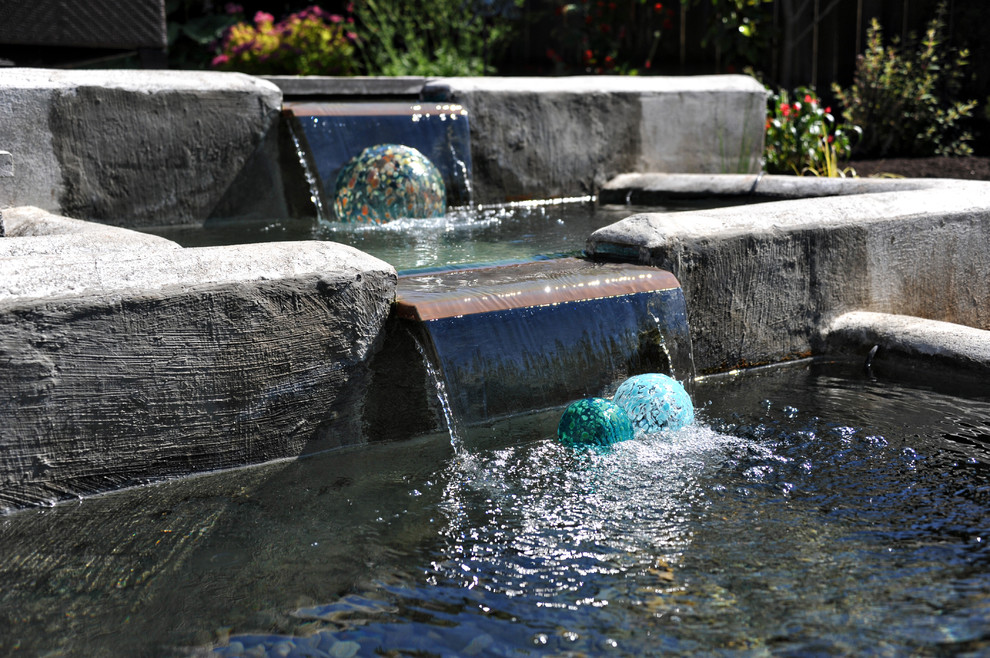 This is an example of a large contemporary full sun backyard stone water fountain landscape in Portland.