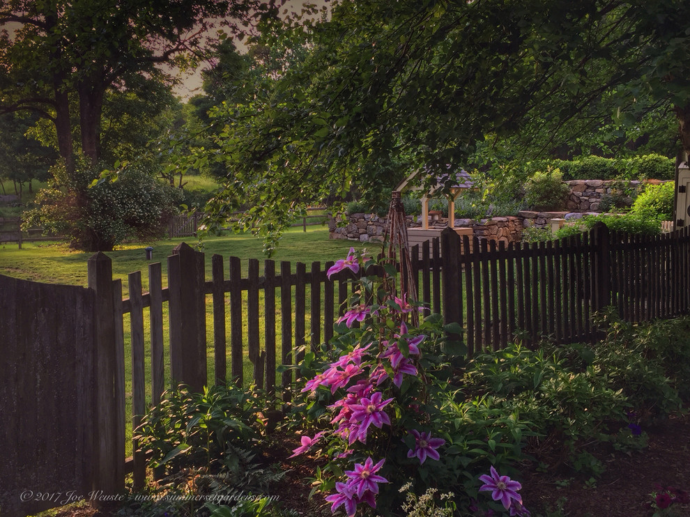 Idee per un giardino country esposto a mezz'ombra di medie dimensioni e dietro casa con un muro di contenimento