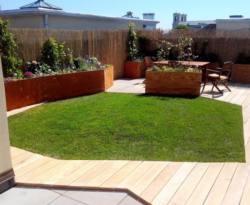 This is an example of a mid-sized contemporary full sun rooftop landscaping in New York with decking for summer.