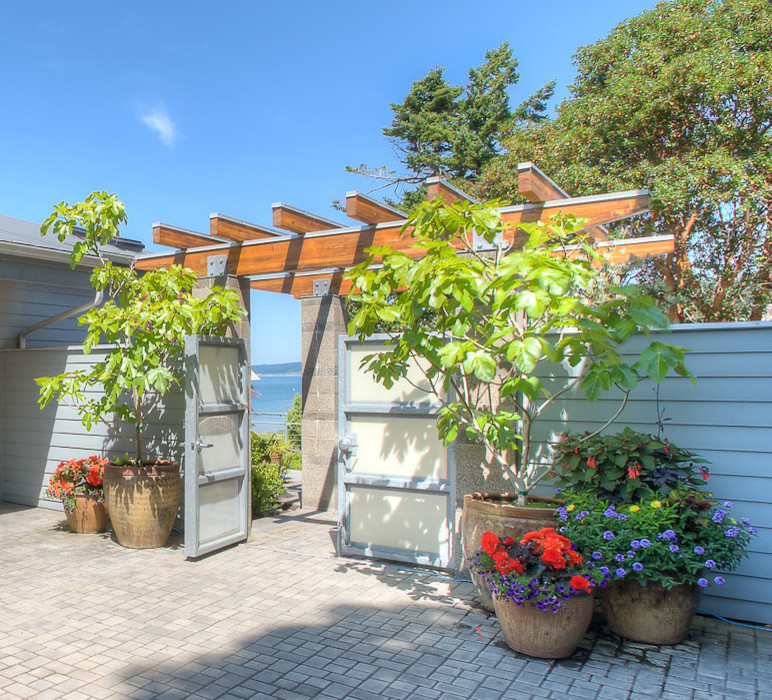 Immagine di un giardino xeriscape minimalista esposto a mezz'ombra di medie dimensioni e in cortile in estate con un giardino in vaso e pavimentazioni in mattoni