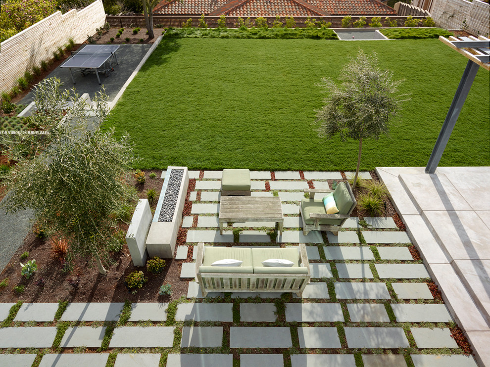Стильный дизайн: большой солнечный, осенний регулярный сад на заднем дворе в стиле модернизм с местом для костра, хорошей освещенностью и покрытием из каменной брусчатки - последний тренд