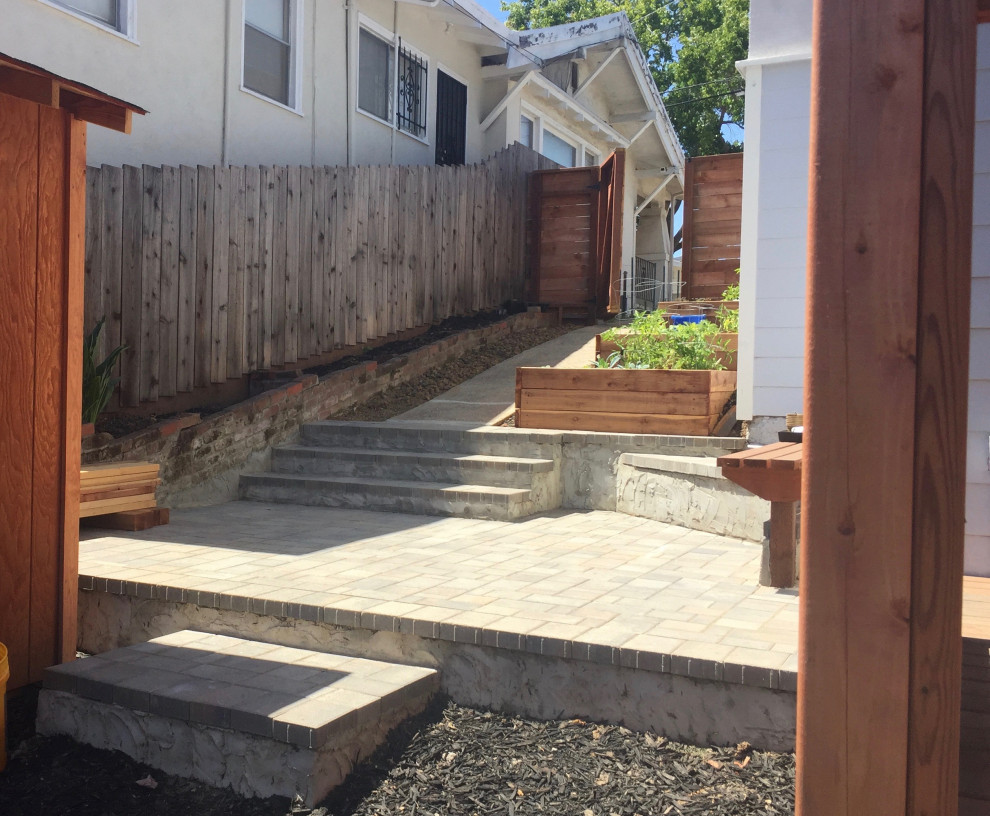 Medium sized classic side driveway partial sun garden for spring in San Francisco with concrete paving and a wood fence.