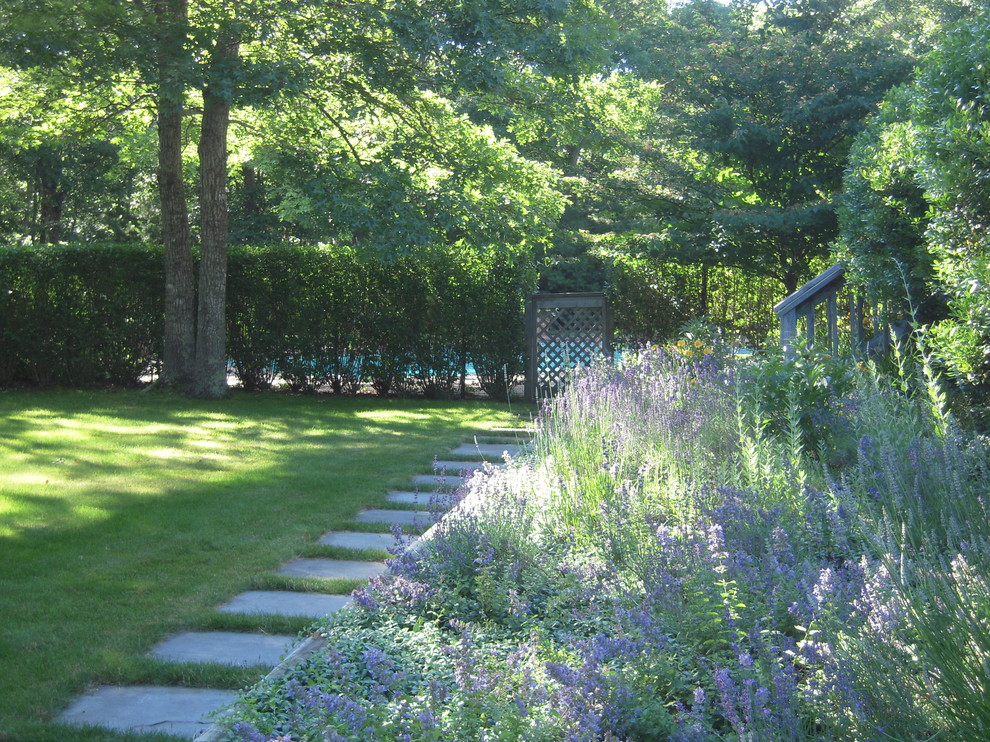 Inspiration för en mellanstor funkis trädgård i delvis sol framför huset på våren, med naturstensplattor