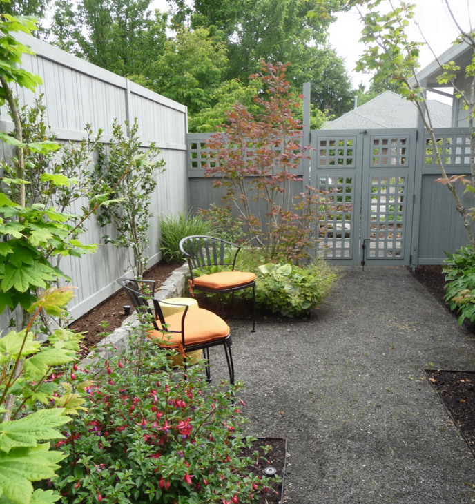 Inspiration för en mellanstor eklektisk trädgård i skuggan längs med huset på våren, med en trädgårdsgång och marksten i betong