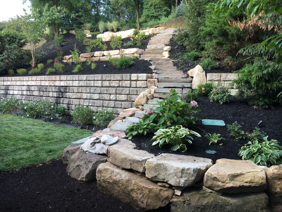 This is an example of a huge contemporary partial sun backyard stone landscaping in Other.