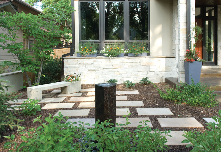Immagine di un giardino contemporaneo davanti casa con pavimentazioni in pietra naturale