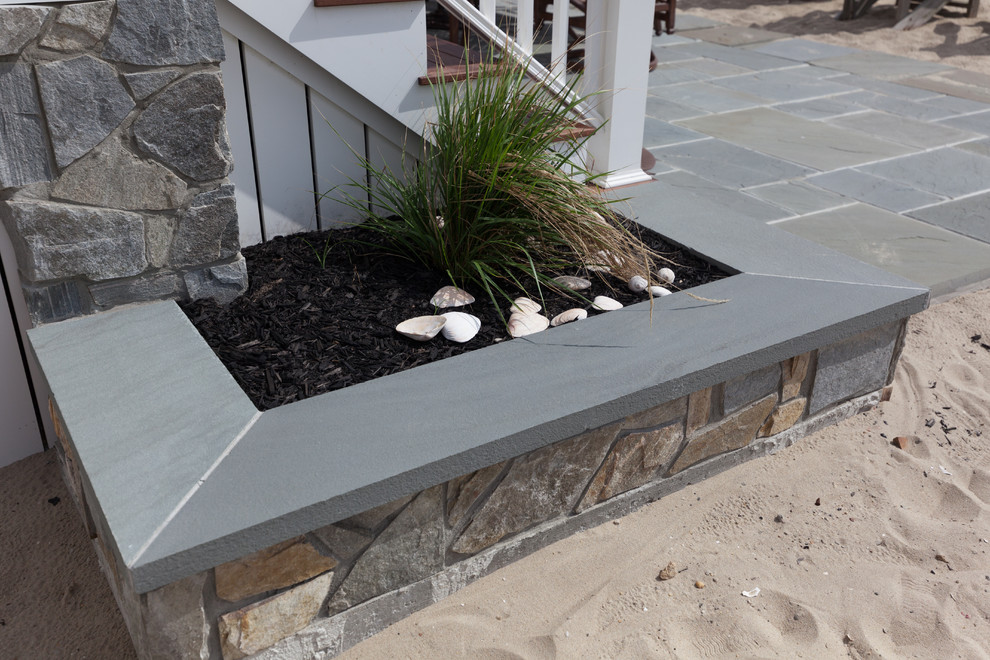 Photo of a mid-sized coastal full sun front yard stone landscaping in New York for summer.