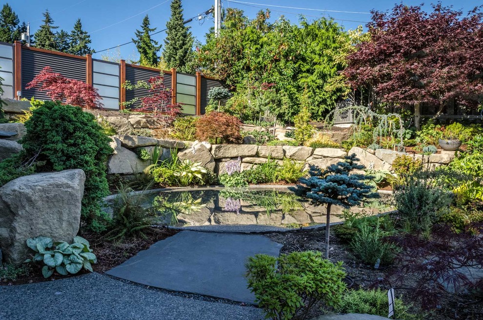 Large classic back partial sun garden in Vancouver with a pond and mulch.