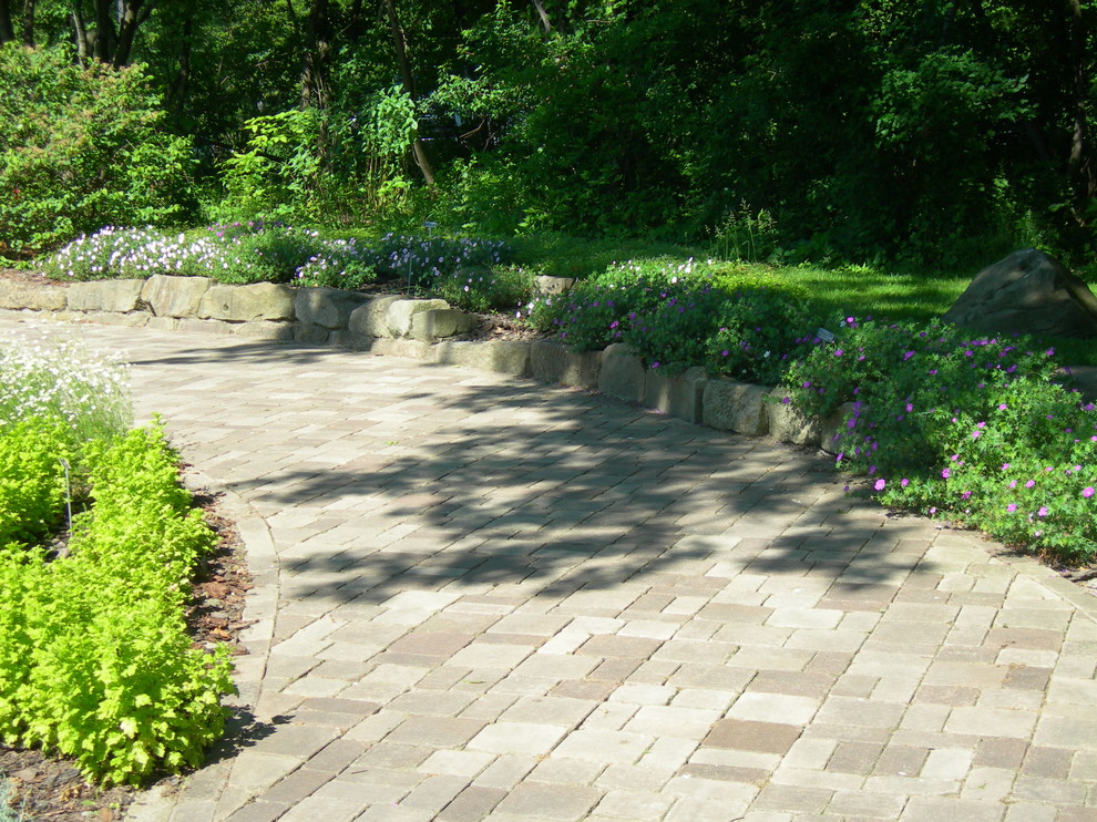 Aménagement d'un grand aménagement d'entrée ou allée de jardin arrière classique au printemps avec une exposition ombragée et des pavés en brique.