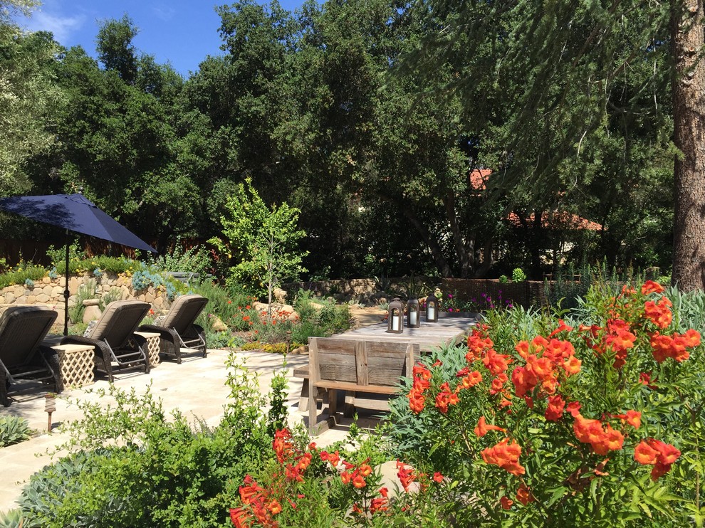 Foto di un giardino mediterraneo dietro casa con pavimentazioni in pietra naturale e un ingresso o sentiero