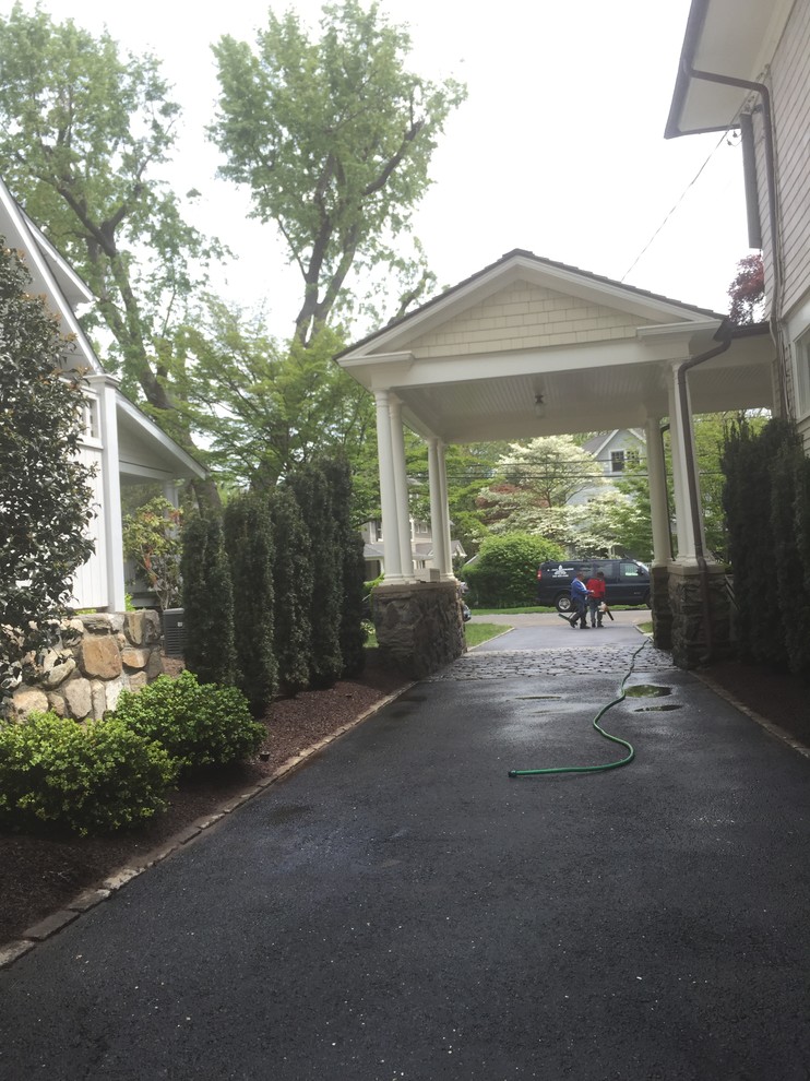 Small traditional side driveway partial sun garden for spring in New York with a garden path and mulch.
