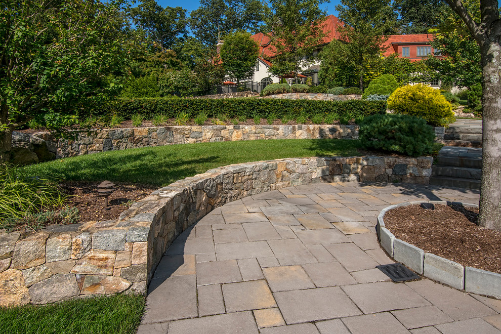 Esempio di un grande giardino tradizionale esposto a mezz'ombra dietro casa in autunno con un muro di contenimento e pavimentazioni in pietra naturale