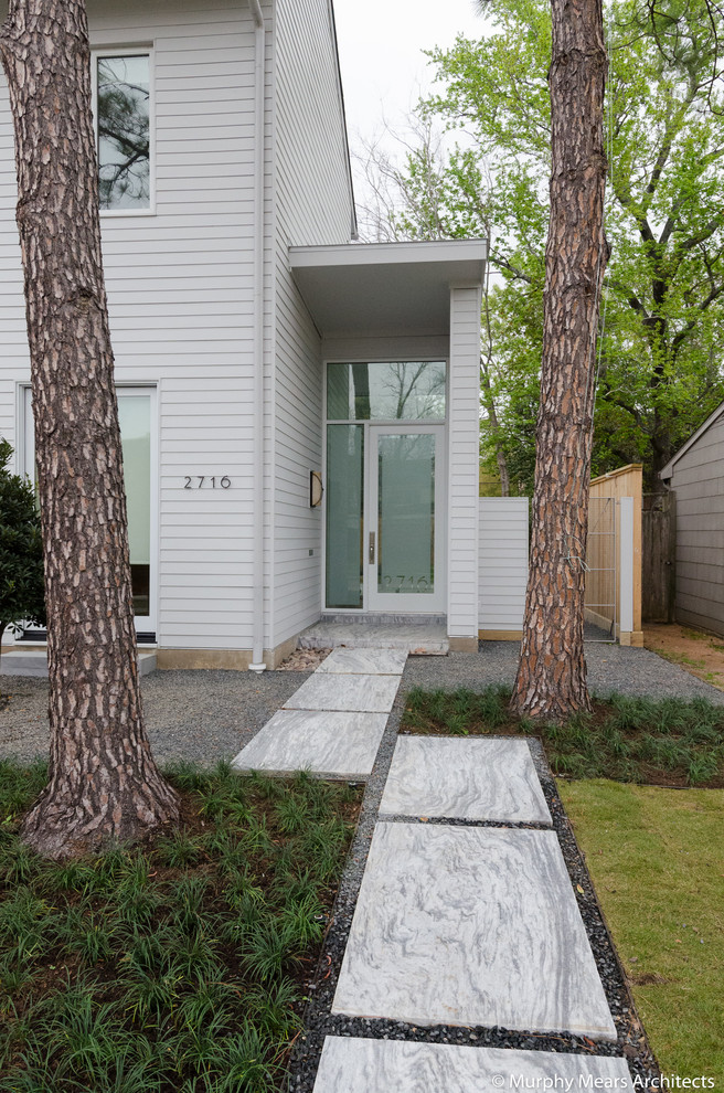 Cette image montre un petit jardin avant design avec une exposition ensoleillée et des pavés en pierre naturelle.