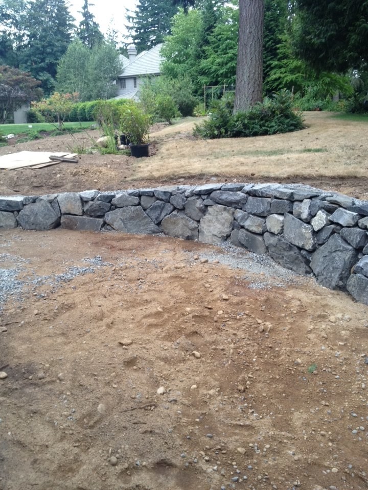 Photo of a mid-sized traditional partial sun front yard stone landscaping in Seattle for summer.