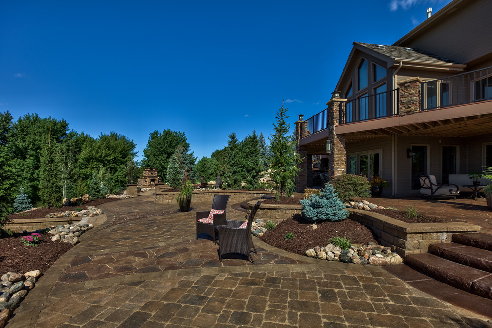Design ideas for a large back full sun garden in Omaha with natural stone paving.