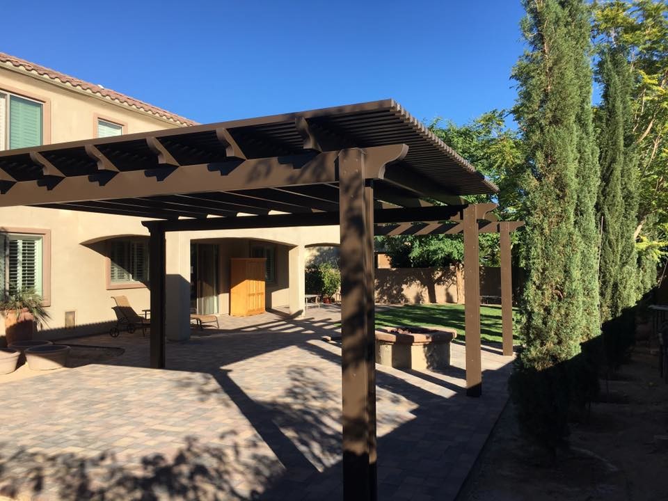 This is an example of a large rustic back formal fully shaded garden for summer in Phoenix with a fire feature and natural stone paving.