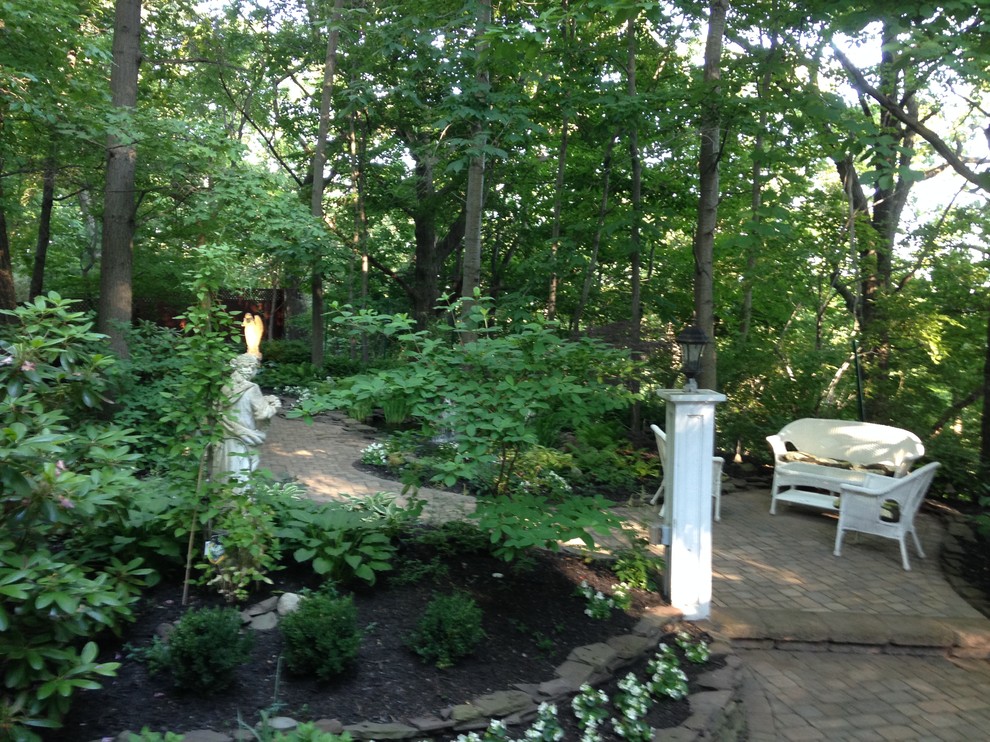 На фото: большой тенистый регулярный сад на заднем дворе в стиле рустика с мощением тротуарной плиткой