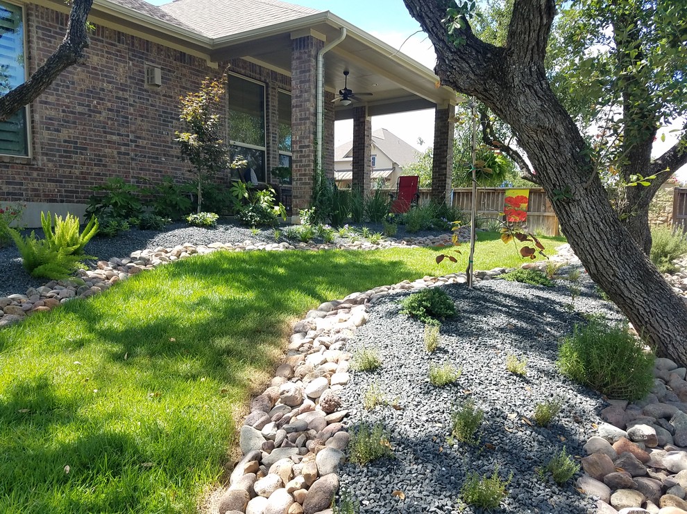 This is an example of a medium sized world-inspired front xeriscape full sun garden for summer in Other with a garden path and natural stone paving.
