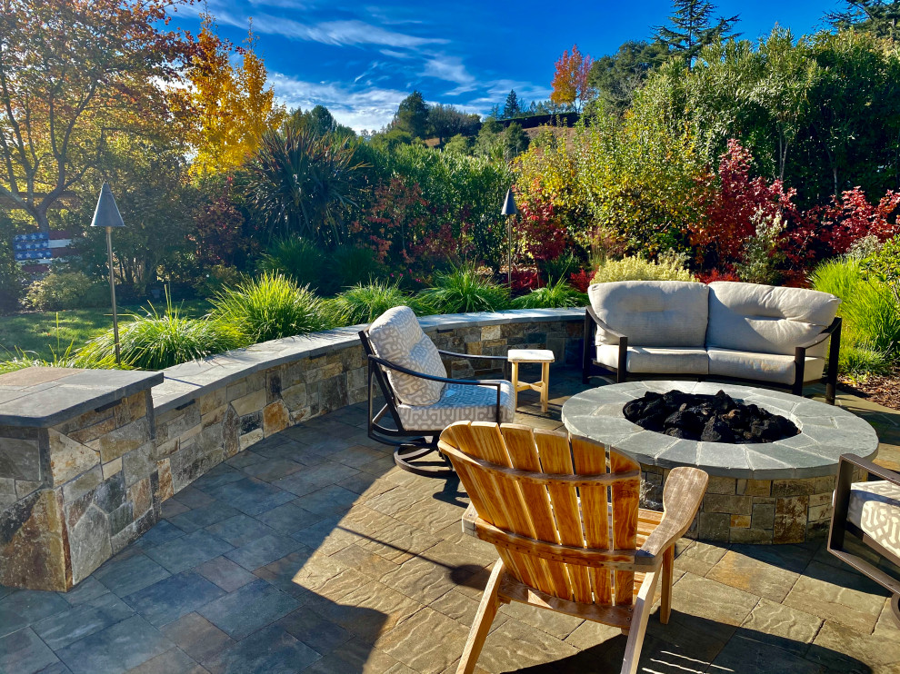 Immagine di un giardino chic esposto in pieno sole di medie dimensioni e dietro casa in autunno con un focolare e pavimentazioni in cemento