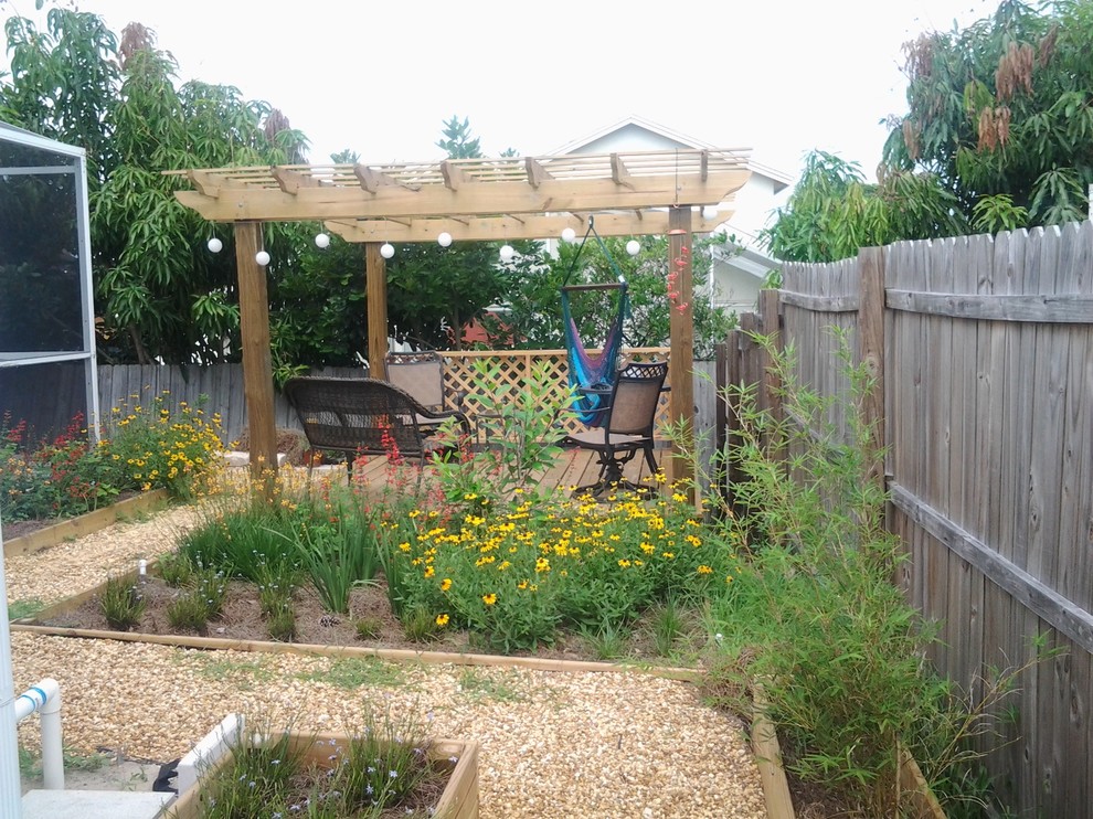 На фото: маленький солнечный участок и сад на заднем дворе в классическом стиле с подпорной стенкой, хорошей освещенностью и покрытием из гравия для на участке и в саду с