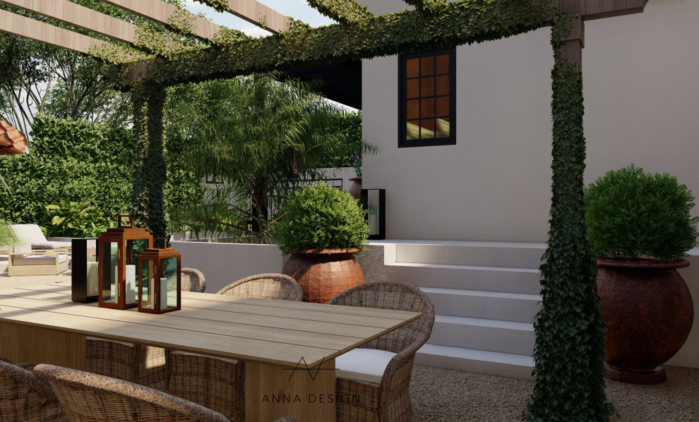 Immagine di un grande giardino formale mediterraneo esposto in pieno sole dietro casa in estate con un caminetto, graniglia di granito e recinzione in pietra