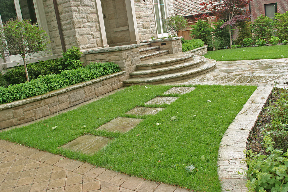Photo of a large traditional partial sun front yard stone garden path in Toronto for summer.