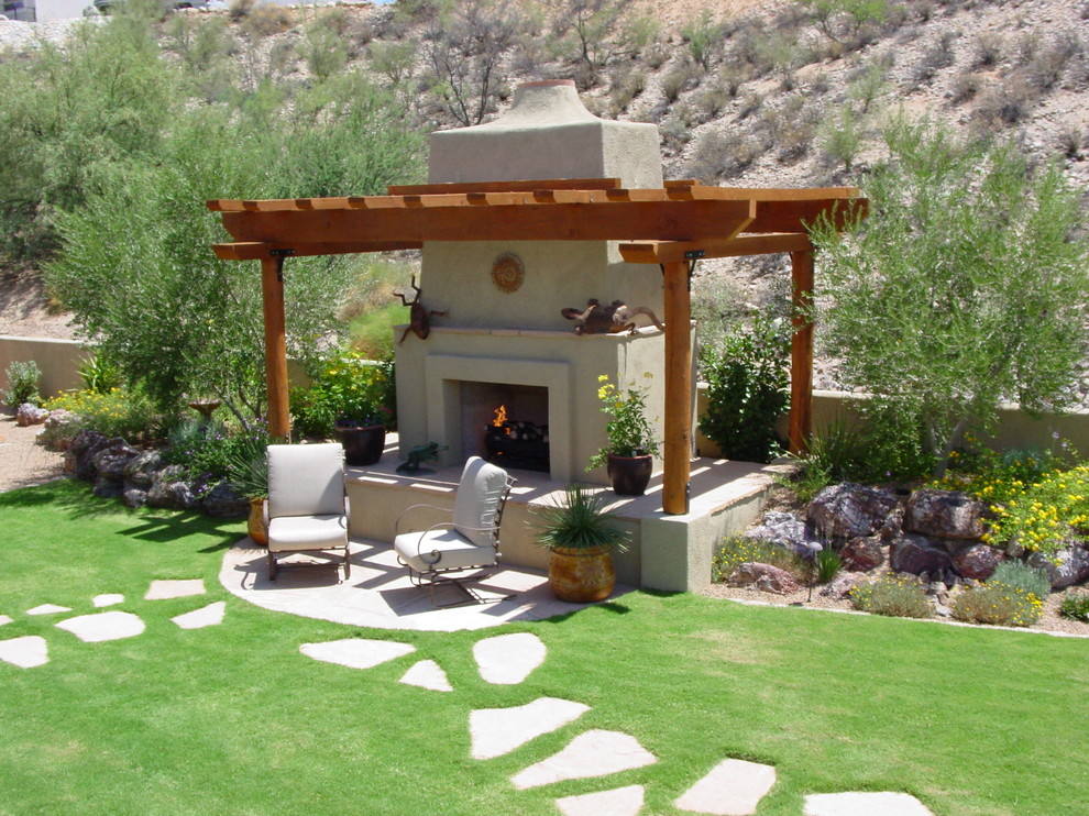 Medium sized back xeriscape full sun garden for summer in Phoenix with concrete paving and a fire feature.